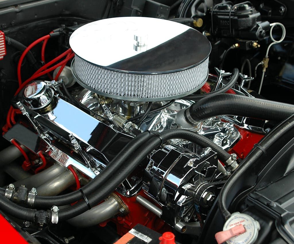 Detailed view of a polished, high-performance car engine showcasing chrome detailing and intricate mechanics.